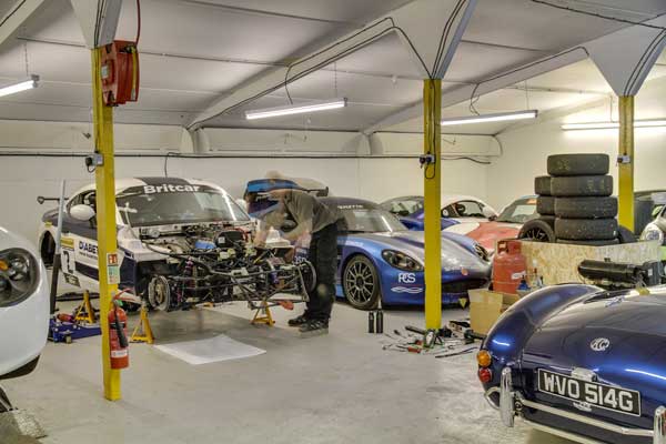 Inside view of the SVG Motor Sport garage, mechanic at work.